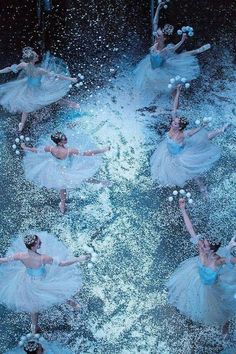 several ballerinas in blue tutus and white dresses are dancing through water with bubbles