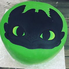 a green and black cake with an image of a cat's head on it