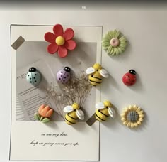 there are many buttons and flowers on the wall next to each other with ladybugs