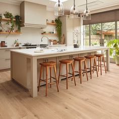 a kitchen island with four stools in front of it