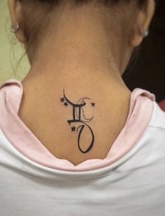 a woman's upper back neck tattoo with the letter f on it and stars