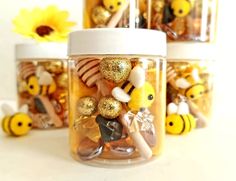 three jars filled with different types of candies and honeybees on top of each other