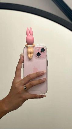 a woman holding up her phone case with an image of a bunny on top of it