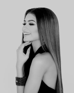 a woman with long hair is posing for a black and white photo, she has her hand on her chin