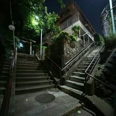 the stairs lead up to an apartment building at night with no one in sight on them