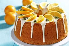 a bundt cake with lemons, oranges and rosemary sprigs on top