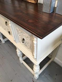 an old dresser is painted white and brown