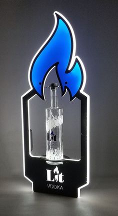 a lit up blue flame on top of a black stand with an acrylic logo