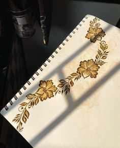 a white notebook with gold designs on it