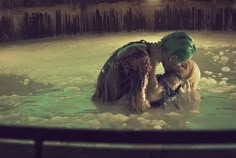 two people are in the water with their heads wrapped around each other and one person is wearing a green turban