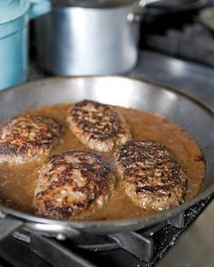 some meatballs are cooking in a pan on the stove