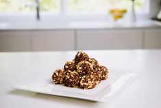 a white plate topped with cookies on top of a kitchen counter next to a window