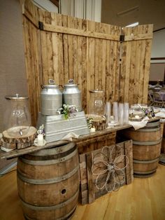 several wooden barrels are stacked on top of each other in front of a wall with wood paneling