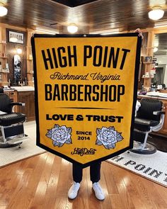 a man holding up a sign that says high point barbershop