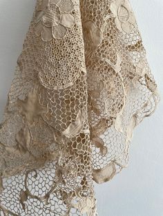 an old lace curtain is hanging on the wall in front of a white wall and floor