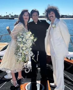 two men and a woman standing on a boat