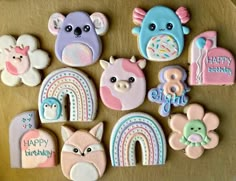 decorated cookies are arranged in the shape of rainbows, bears, and unicorns