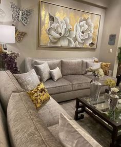 a living room filled with lots of furniture next to a wall mounted flower painting on the wall