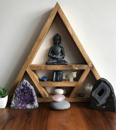 a wooden shelf with various items on it and a buddha statue in the corner next to it