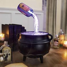 a black caulder filled with liquid sitting on top of a table next to books