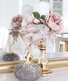 a mirror with flowers and candles on top of it next to a vase filled with roses