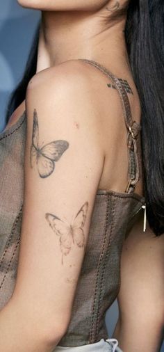 a woman with butterfly tattoos on her shoulder