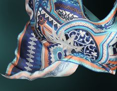 a blue and orange scarf with an intricate design on the front, hanging from a hook