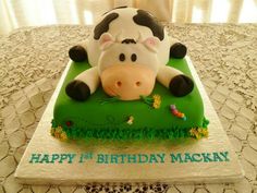 a birthday cake with a cow laying on it