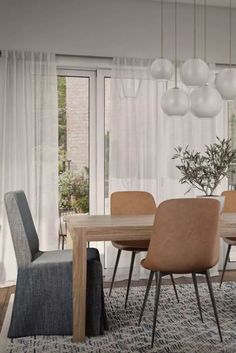 a dining room table and chairs in front of a large window with white drapes