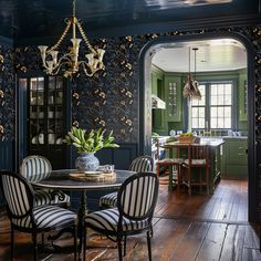 a dining room with green walls and wooden floors