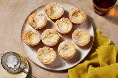 small pastries on a plate next to a cup of tea