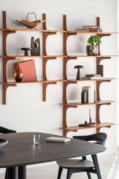 a table and chairs in a room with shelves on the wall