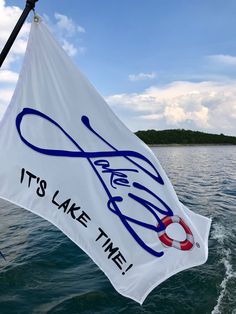 a sign that says it's lake time hanging from the side of a boat