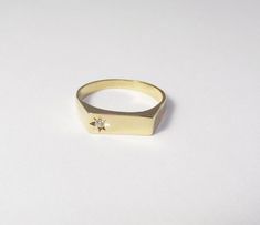 A 14k solid gold signet engagement ring with a diamond. This lovely minimal and clean designed signet ring is made of solid 14k gold and has a small diamond on one side (1.5 ct). The shiny diamond is set in a star designed inlay, which gives this ring yet more character and sparkle. This ring can be a great modern engagement ring or a high-class gift for any other happy occasion such as birthdays, births, anniversaries and more. This rin is great for everyday use - it is light and comfortable to Signet Engagement Ring, Signet Ring Diamond, Signet Engagement Rings, Pretty Promise Rings, Modern Engagement Ring, Diamond Promise Ring, Diamond Signet Ring, Zierlicher Ring, Modern Engagement Rings