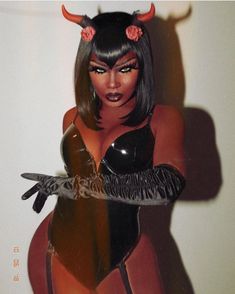 a woman with horns on her head is holding a knife in one hand and wearing a black bodysuit