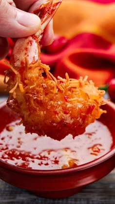 a person dipping some food into a bowl