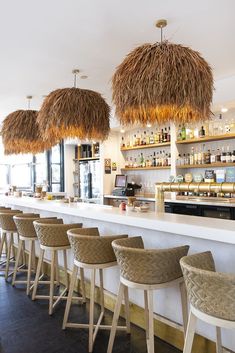 the bar is decorated with tiki straws hanging from the ceiling and chairs are lined up