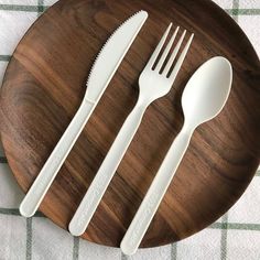 three forks and two spoons on a wooden plate