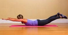 a woman doing push ups on a pink mat