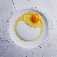 a white plate topped with an egg on top of it