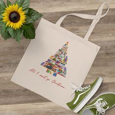 This holiday-themed tote bag features a festive tree made of books, perfect for the book lovers and literary enthusiasts in your life. It exudes a cozy and joyful Christmas vibe, making it a great accessory for shopping, work, or everyday use during the holiday season. This tote bag is relevant for Christmas and book-related celebrations and occasions. Product features - 100% Cotton for durability and smooth printing - Comfortable cotton web handles for easy carrying - Flat corners for a sleek l Literary Tote Bag For Gift, Christmas Tree Tote, Books Tote Bag, Winter Reading, Christmas Vibe, Book Tree, Book Tote Bag, White Cross, Christmas Canvas