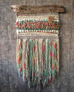 a woven wall hanging with fringes and beads