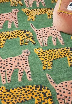 a green rug with yellow and black giraffes on it