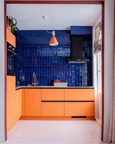 an orange kitchen with blue tiles on the wall