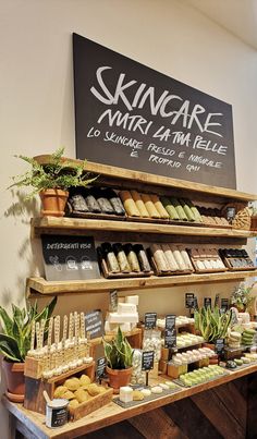 an assortment of skin care products displayed on shelves in a store with a sign above it