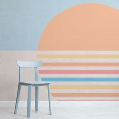 a chair sitting in front of a wall with an orange and blue circle on it