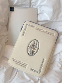 an open laptop computer sitting on top of a white bed next to a pillow and blanket