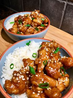 two bowls filled with chicken and rice on top of a wooden table