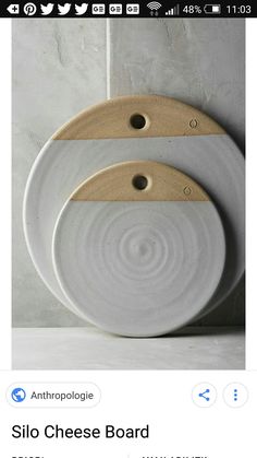 two white plates sitting on top of each other with wooden cutting boards attached to them