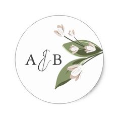 a round sticker with white flowers and green leaves on the bottom that says ab